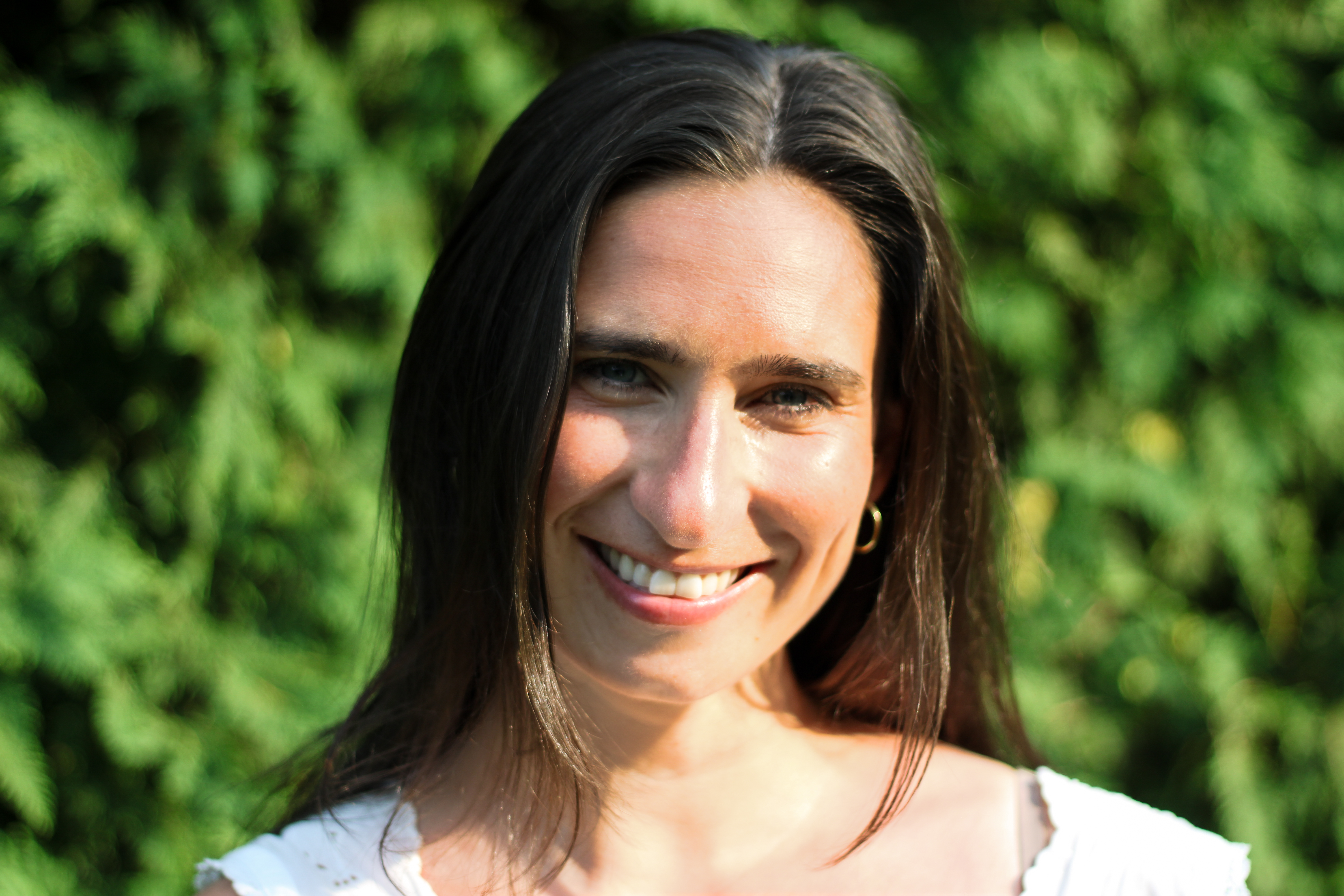 Close-up portrait of Sarah smiling in warm evening light