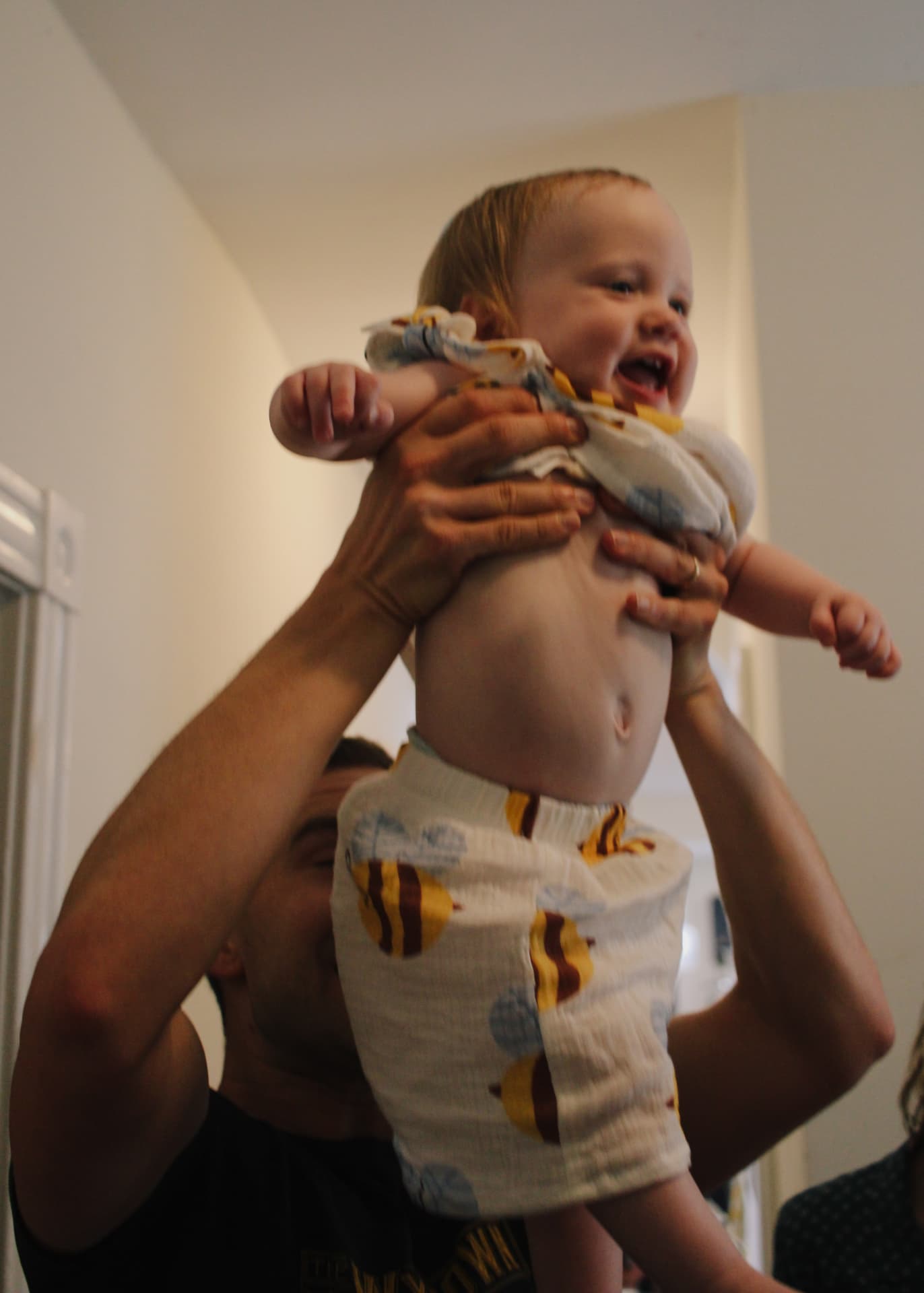 Phoebe lifted up smiling in her bee-themed birthday outfit