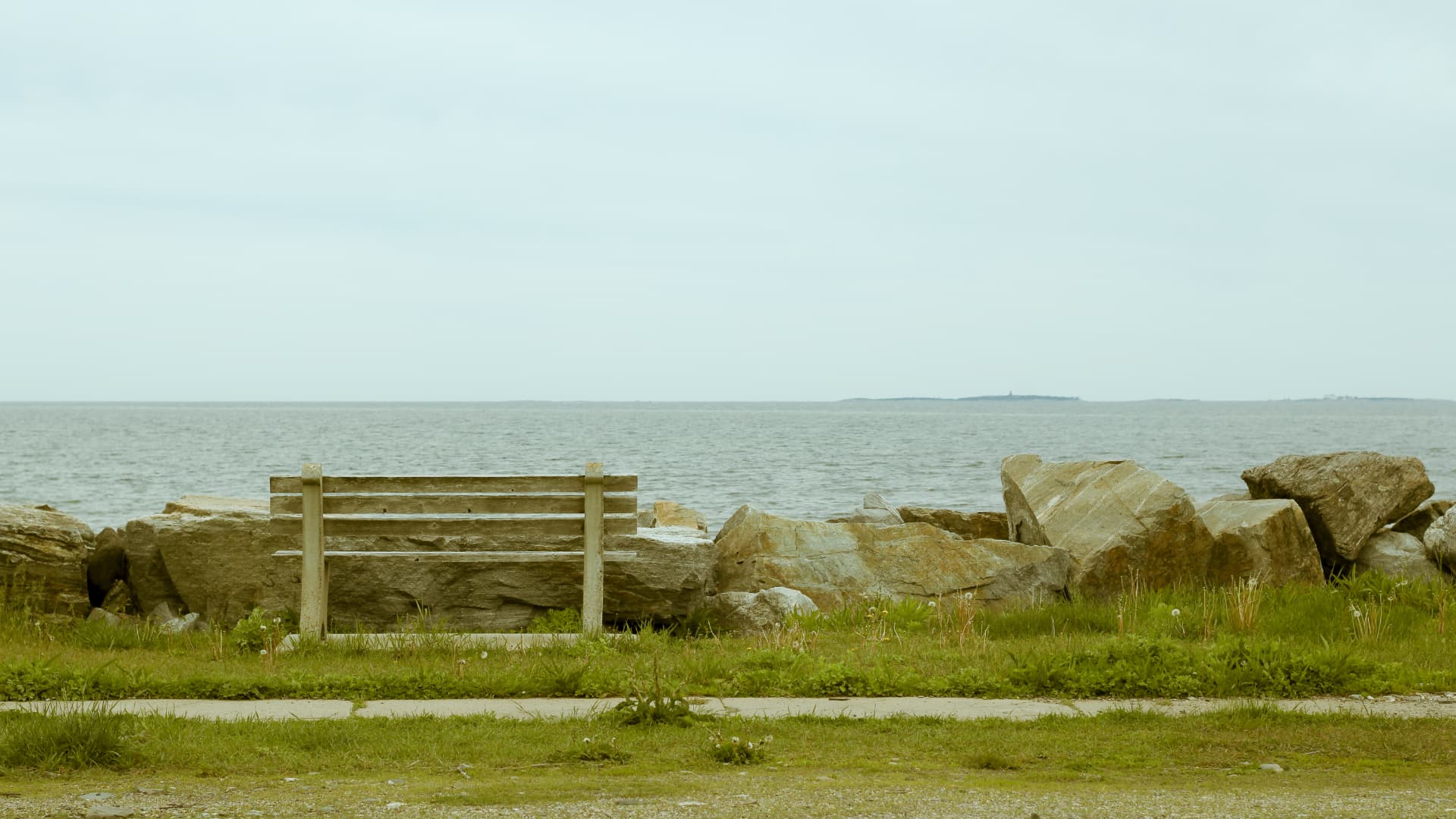 Weathered wooden bench overlooking the Atlantic on the rocky Rye, New Hampshire coastline