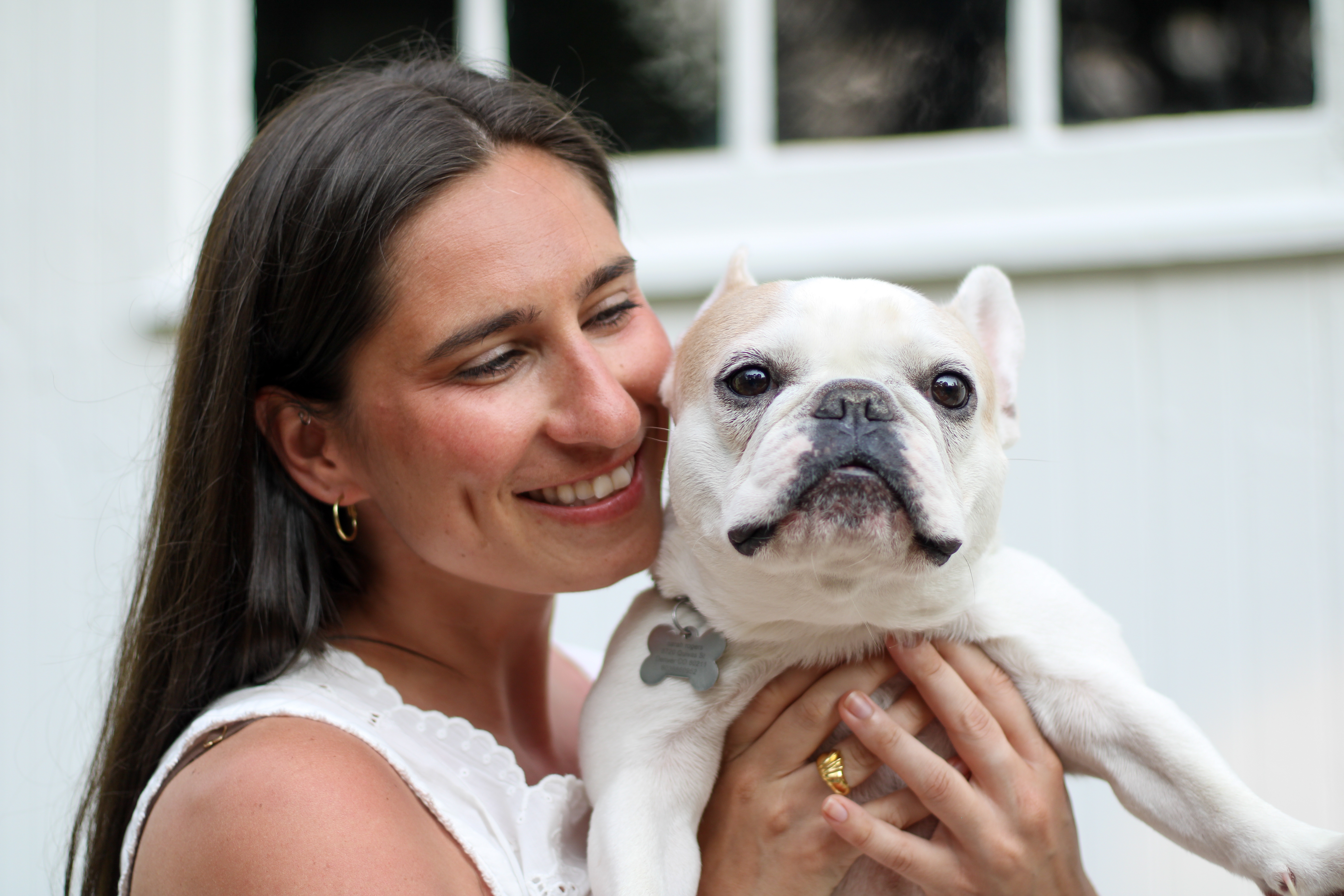 Sarah resting her cheek against her French bulldog's head