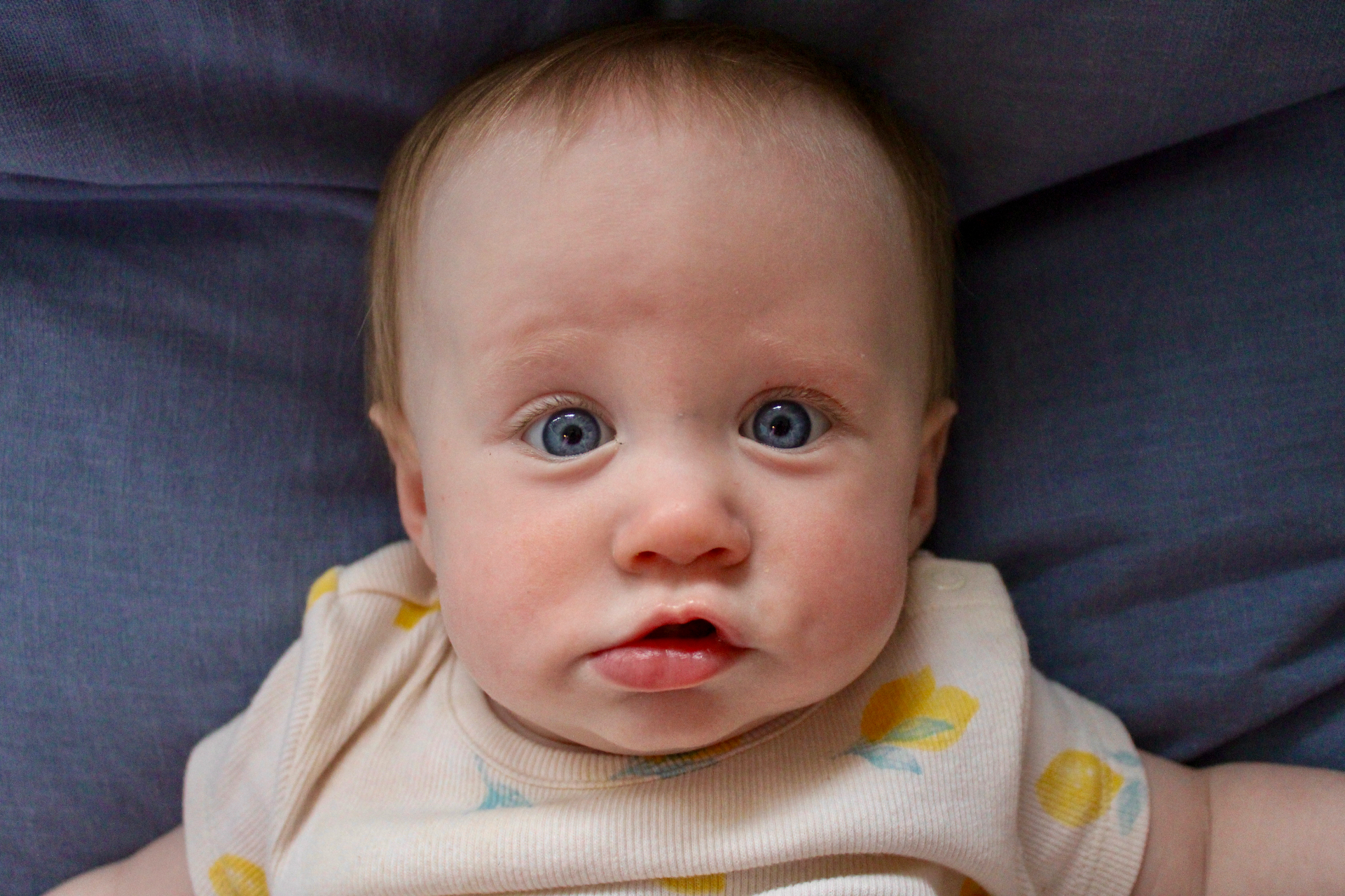 A young child with bright blue eyes looking up at the camera