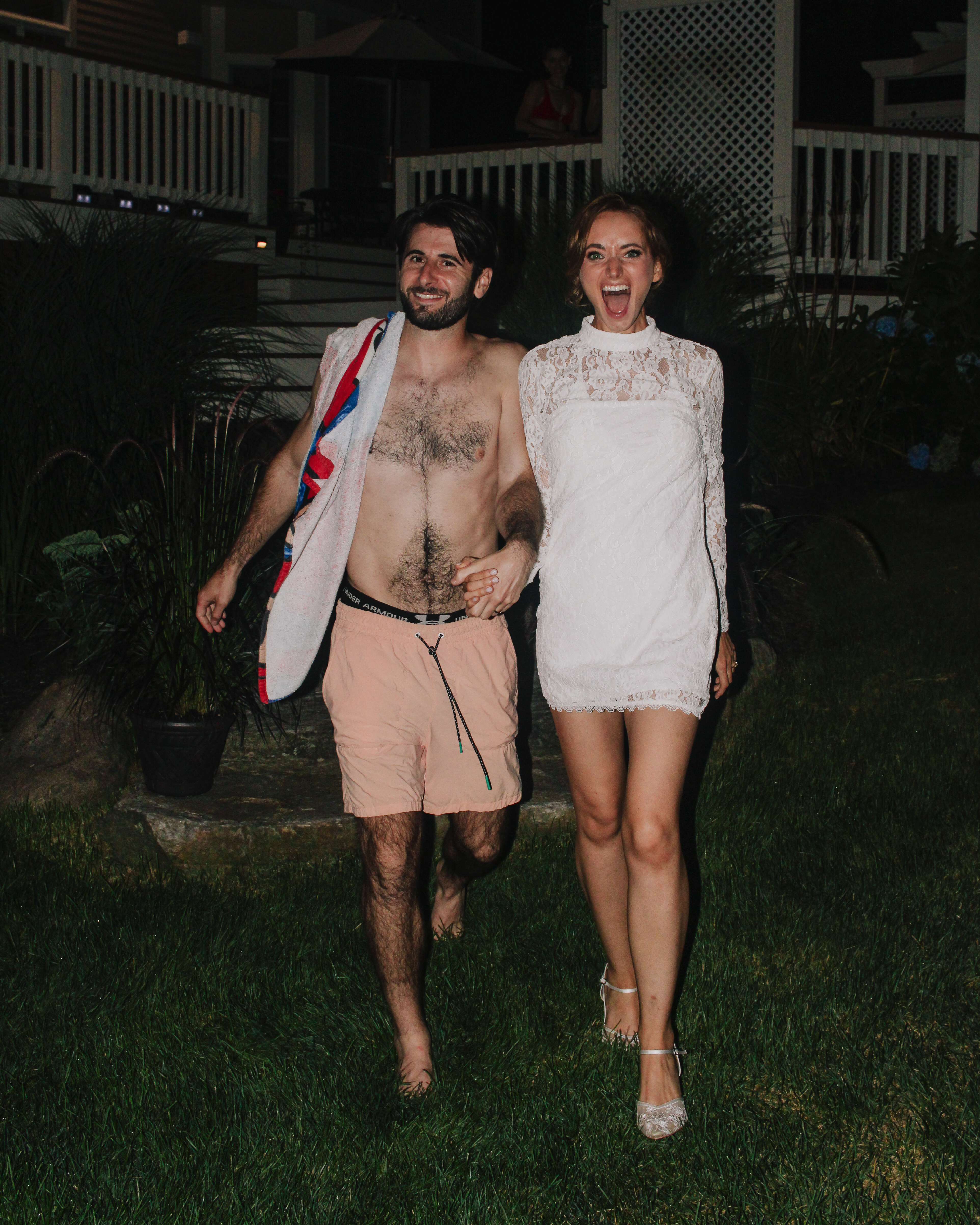 Caroline and Jamie laughing as they walk across the lawn after the pool party
