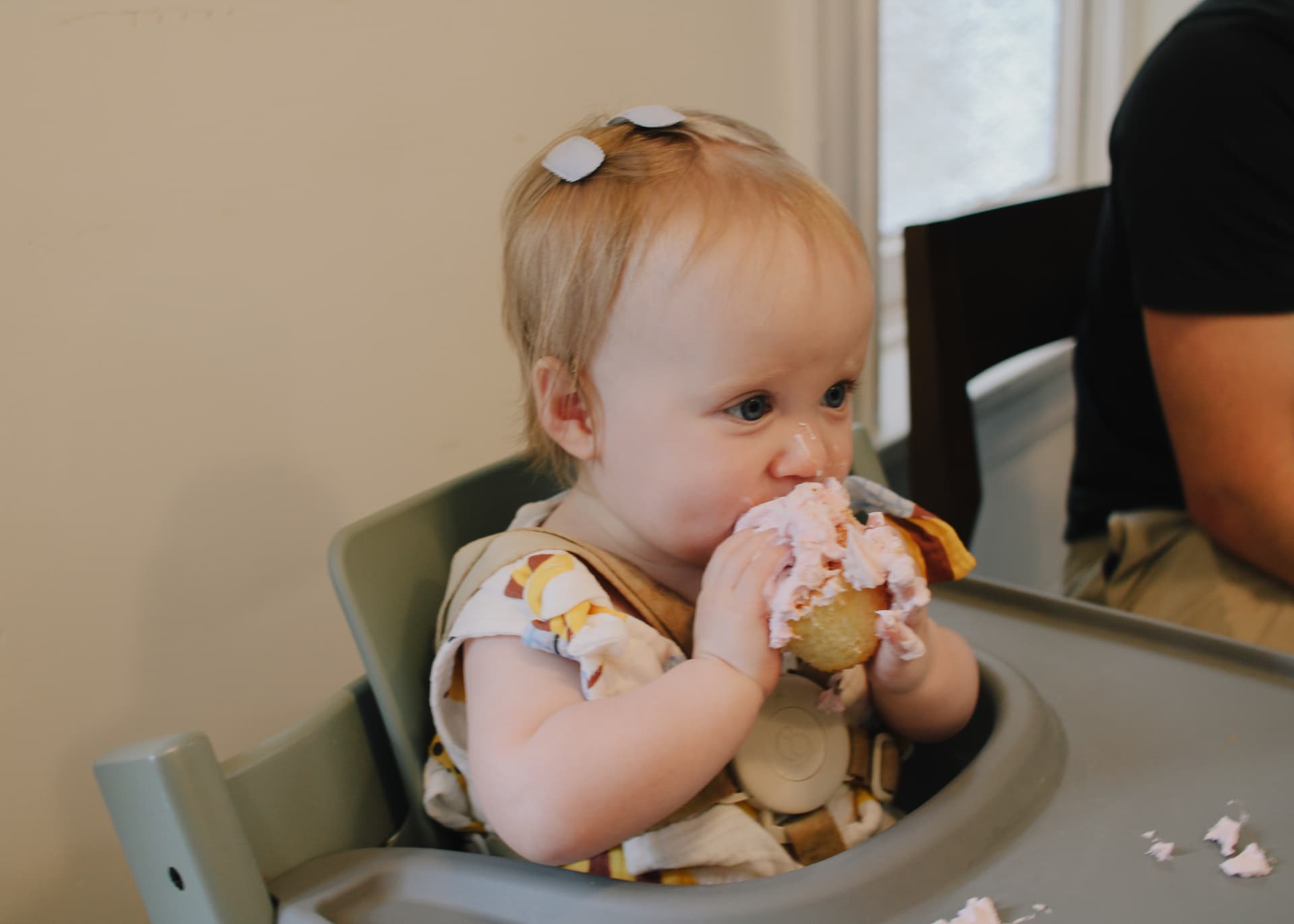 Phoebe taking a big bite of her pink frosted cupcake